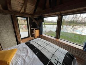 Saint-Laurent-des-HommesLa maison de l'O的带窗户的房间里有一张床的卧室