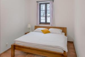 Schlafzimmer mit einem Bett mit weißer Bettwäsche und einem Fenster in der Unterkunft Dvůr Lískový vrch in Strážný