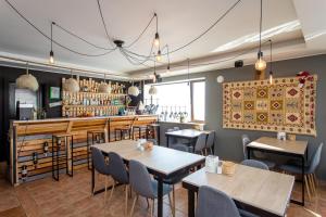 a restaurant with tables and chairs and a bar at Hotel VERANDA in Gudauri