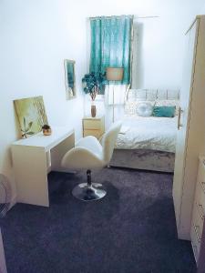a bedroom with a white desk and a white chair at COSY DOUBLE ROOM CLOSE TO UNIVERSITY OF BRADFORD AND CITY CENTRE in Bradford