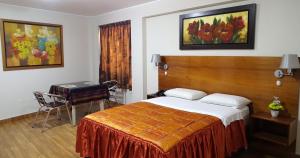 Hospedaje Dimar Inn في ليما: غرفة نوم بسرير وطاولة وكرسي