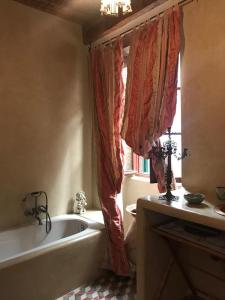 a bathroom with a bath tub and a window at Via Col Tempo in Pigna