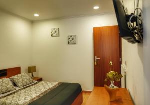 a bedroom with a bed and a tv in it at Vale dos Encantos in Furnas