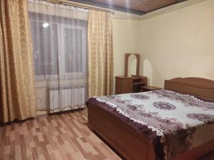 a bedroom with a bed and a window with curtains at Долина Карпат in Slavske +11 photos