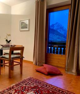 um quarto com uma mesa e uma janela com vista em Cima de’ Piazzi Apartment em Isolaccia
