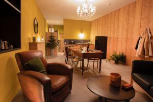 a living room with a table and chairs and a kitchen at Appartement avec sauna au pied de la citadelle in Besançon