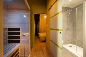 y baño con ducha a ras de suelo y bañera. en Appartement avec sauna au pied de la citadelle, en Besançon