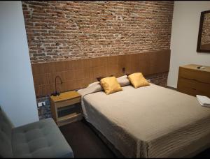 1 dormitorio con cama y pared de ladrillo en HOTEL BOUTIQUE PANAMÁ en Guayaquil