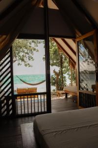 a bedroom with a view of the ocean and a hammock at Hotel Islabela Islas Del Rosario in Isla Grande