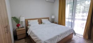 a bedroom with a white bed and a window at Amy's appartment Coastal road Peyrebere in Pereybere