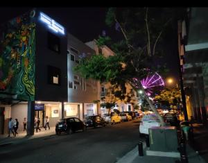 a city street at night with cars parked on the street at HOTEL BOUTIQUE PANAMÁ in Guayaquil