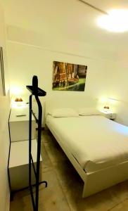 ein Schlafzimmer mit einem weißen Bett und einem Bild an der Wand in der Unterkunft CASTELLO Ground Floor in Venedig