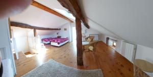 um quarto no sótão com uma cama e uma mesa em La Bruyère - chez Martine em Appy