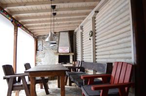 a dining room with a table and chairs and a fireplace at Yakusha - Якуша, къща за гости in Shiroka Laka