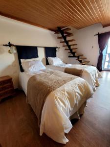 a bedroom with two beds and a staircase at Anqas Apartment Cusco in Cusco