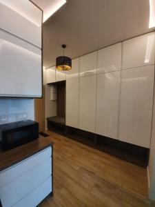 eine große Küche mit weißen Schränken und einem Kronleuchter in der Unterkunft Apartament Skarbowa in Leszno