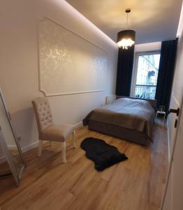 Un dormitorio con una cama y una silla y una ventana. en Apartament Skarbowa, en Leszno 4 fotos más
