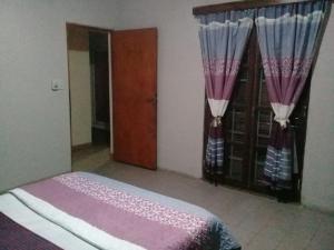 um quarto com uma cama com cortinas roxas e uma porta em Óga Rory em Corrientes