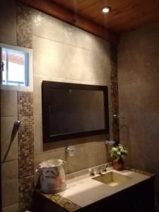 a bathroom with a sink and a television on the wall at Óga Rory in Corrientes