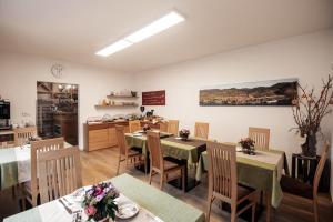 ein Restaurant mit Tischen und Stühlen und eine Küche in der Unterkunft Winzerhof & Gästehaus Bernhard in Weissenkirchen in der Wachau