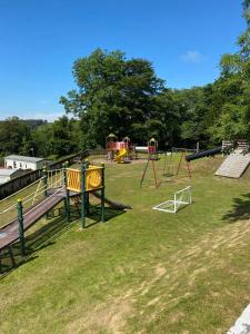 a park with a playground with slides and swings at Unique Caravan with Outdoor Space Lodge in Ballantrae