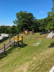 a park with a playground with slides and swings at Unique Caravan with Outdoor Space Lodge in Ballantrae +34 photos