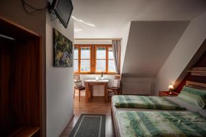 a bedroom with two beds and a table and a window at Winzerhof & Gästehaus Bernhard in Weissenkirchen in der Wachau