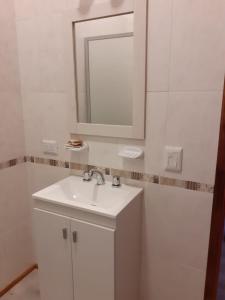a white bathroom with a sink and a mirror at Posada Shalimar in Villa Icho Cruz