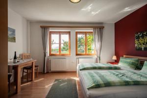 a bedroom with a bed and a desk and window at Winzerhof & Gästehaus Bernhard in Weissenkirchen in der Wachau