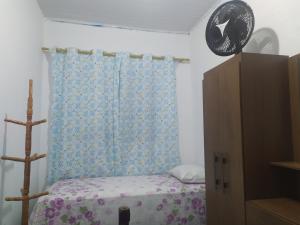 a bedroom with a bed and a blue curtain at Quarto Triplo Solteiro in Barueri