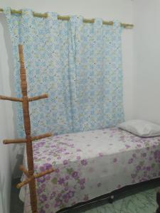 a bedroom with a bed with a blue and purple curtain at Quarto Triplo Solteiro in Barueri