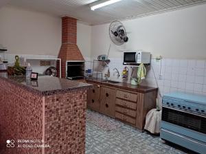 a large kitchen with a stove and a microwave at Casa Olímpia Thermas in Olímpia
