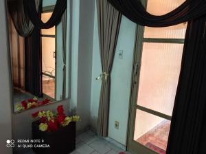 a room with a door and a window with flowers at Casa Olímpia Thermas in Olímpia