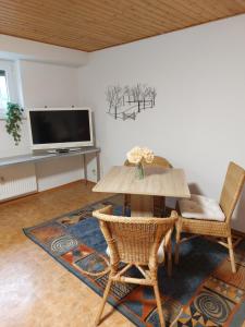 sala de estar con mesa, sillas y TV en Ferienwohnung Juco en Heddesheim