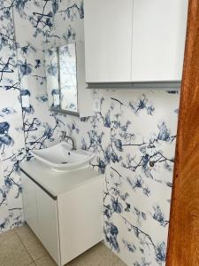 a bathroom with a sink and blue and white wallpaper at Apartamento no Farol da Barra. Vista deslumbrante para o mar! No circuito do Carnaval. Ao lado do Porto da Barra ! in Salvador