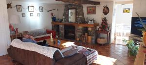 a person sitting on a couch in a living room at La Bruyère - chez Martine in Appy