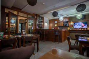 un restaurante con mesas y TV y un bar en Hotel Theatre, en Bitola