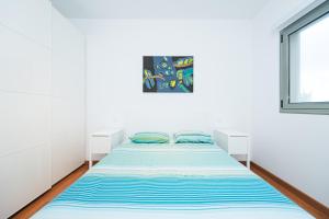 Un dormitorio con una cama en una habitación blanca. en Alojamiento en primera línea de playa en Arinaga, en Arinaga