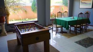 a dining room with a table and a green table and chairs at Belíssima Casa com extensa área externa - piscina, sauna, churrasqueira e campo de futebol - com 5 suítes e a 500 metros da Rua das Pedras in Búzios