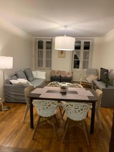 een woonkamer met een tafel en een bank bij Grand appartement tout confort en plein coeur d'Arbois in Arbois