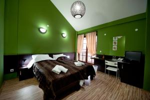 um quarto verde com uma cama e uma secretária em Hotel Theatre em Bitola