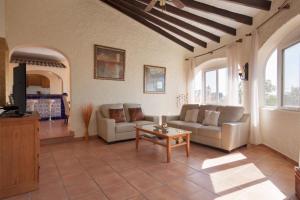 een woonkamer met 2 banken en een tafel bij Villa Carmen - Plusholidays in Calpe
