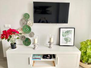 a white cabinet with two candles and a tv on a wall at Luxury Attics Avenida Italia PARKING INCLUIDO in Huelva