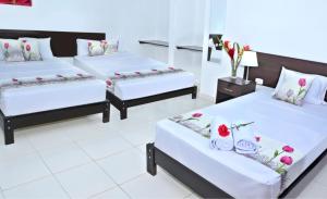 two beds in a room with flowers on them at Residencial Lago Verde in Tarapoto