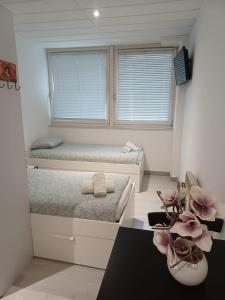 1 dormitorio con 2 camas y ventana en Apparthotel AREA, Studios avec salle de bain et kitchenette Privées, OU, chambres avec salles bain et cuisines communes, en Persan