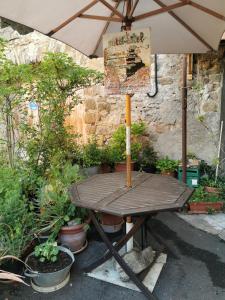 a wooden table with an umbrella and some plants at Mini-Hôtel de Camps in Camps-sur-lʼAgly