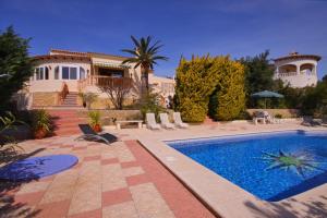 een villa met een zwembad en een huis bij Villa Carmen - Plusholidays in Calpe