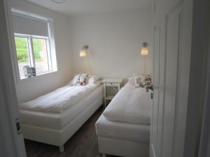 a small bedroom with two beds and a window at Apartment by the Sea in Höfn