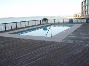 a swimming pool on a deck next to the water at Beautiful Beach Condo in Pensacola Beach