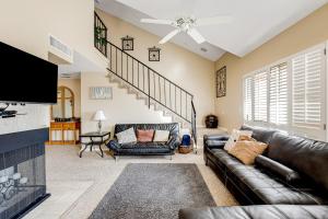 a living room with a leather couch and a tv at Penthouse at the Village in St. George